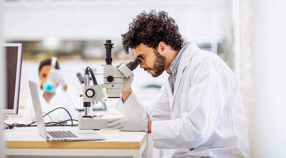 Researcher examining samples through a microscope in a medical laboratory